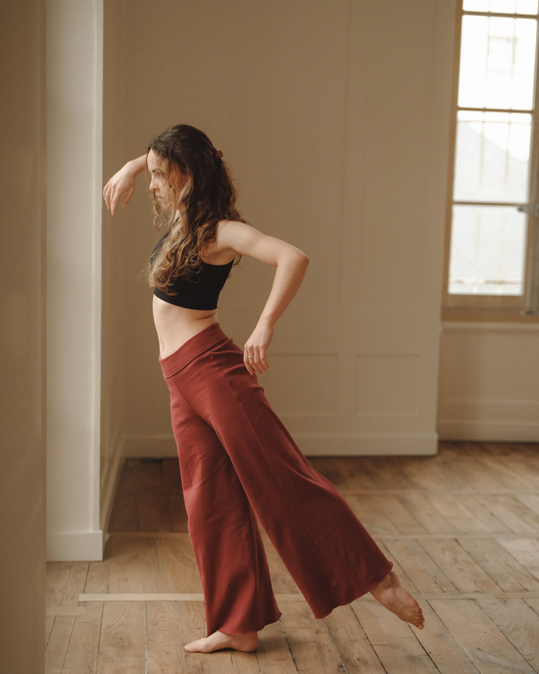 Danseuse en mouvement, pieds nus sur le parquet du studio Cambre.